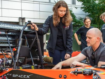 Engineering student working on SpaceX machine with faculty member.