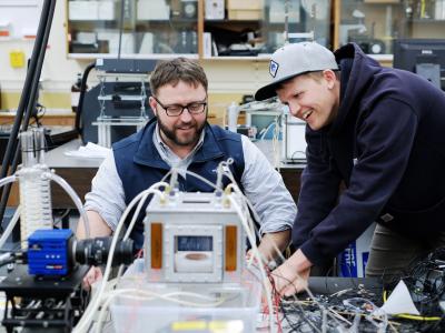 Faculty member Joshua Gess in a lab with a researcher.