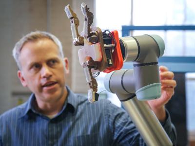 Joe Davidson holding a robotic hand.