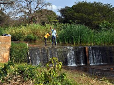 Two people with equipment low head dam.