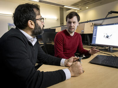 Two colleagues having a discussion in front of a computer.