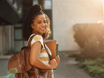 A student looking back at the camera smiling