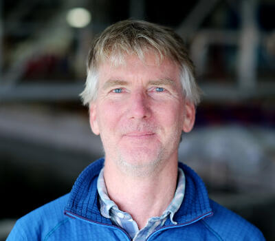 Man wearing blue jacket facing camera.