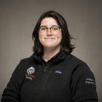 A person wearing a oregon state jacket and glass is posing for the camera