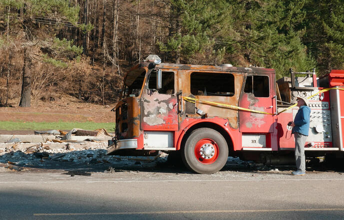 A man standing next to a firetruck.